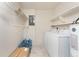 Bright laundry room features white appliances, shelving, tile floors, and storage space for convenience at 22481 Westchester Blvd # B48, Punta Gorda, FL 33980
