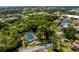 Aerial view of a community pool surrounded by mature trees and a paved parking area at 22481 Westchester Blvd # B48, Punta Gorda, FL 33980