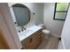 Bathroom with a round mirror and a modern single sink vanity at 23273 Abeline Ave, Punta Gorda, FL 33980