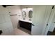 Bathroom with double sink vanity, wood cabinets, oval mirrors and modern fixtures at 23273 Abeline Ave, Punta Gorda, FL 33980