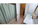 Bathroom featuring tub/shower with a curtain, vanity sink, and doorway to laundry room at 23273 Abeline Ave, Punta Gorda, FL 33980