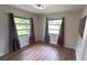 Cozy bedroom with hardwood floors, two windows, and neutral paint at 23273 Abeline Ave, Punta Gorda, FL 33980