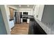 Modern kitchen with white cabinetry, stainless steel appliances, and black countertops at 23273 Abeline Ave, Punta Gorda, FL 33980