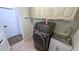 Laundry room features new grey washer and dryer, overhead storage, and utility sink at 23273 Abeline Ave, Punta Gorda, FL 33980