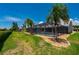 Expansive backyard with a screened pool, mature palm trees, and meticulously kept grounds at 25371 Paladin Ln, Punta Gorda, FL 33983