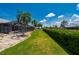 Landscaped backyard with vibrant green grass, screened pool area, and well-trimmed hedges at 25371 Paladin Ln, Punta Gorda, FL 33983
