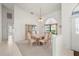 Airy dining area featuring carpeted floors, ample lighting, a formal table set, and views of a window, perfect for entertaining at 25371 Paladin Ln, Punta Gorda, FL 33983
