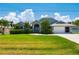 Attractive home boasting a well-kept lawn, vibrant bushes, palm trees, and a charming arched entryway, radiating warmth at 25371 Paladin Ln, Punta Gorda, FL 33983