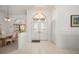 Bright entryway showcasing tiled flooring, a chandelier, and a dining area that creates an inviting first impression at 25371 Paladin Ln, Punta Gorda, FL 33983