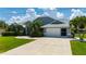 Charming single-story home showcasing well-manicured lawn, complemented by vibrant green shrubs and mature palm trees at 25371 Paladin Ln, Punta Gorda, FL 33983