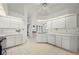 A well-lit kitchen featuring white cabinets, tile flooring, and stainless steel appliances at 25371 Paladin Ln, Punta Gorda, FL 33983