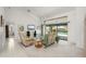 Bright living room featuring comfortable seating, ceiling fan and sliding glass doors to pool at 25371 Paladin Ln, Punta Gorda, FL 33983
