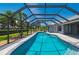 Enclosed pool surrounded by lush greenery and mature palm trees, offering a private retreat at 25371 Paladin Ln, Punta Gorda, FL 33983