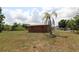 Exterior featuring solar panels, desert landscaping, and a lush green lawn with trees at 28024 Cleveland Ave, Punta Gorda, FL 33982