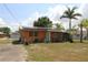Charming single-story home with a welcoming front porch, set amidst a lush lawn and mature palm trees at 28024 Cleveland Ave, Punta Gorda, FL 33982