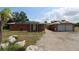 Exterior view of home and detached garage with solar panels, complemented by a concrete driveway at 28024 Cleveland Ave, Punta Gorda, FL 33982
