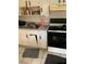 Functional kitchen with basic appliances and white cabinetry; cabinet door is off hinge at 28024 Cleveland Ave, Punta Gorda, FL 33982