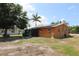 View of home's rear with an attached screened in area and a spacious yard at 28024 Cleveland Ave, Punta Gorda, FL 33982