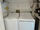 Laundry room featuring a washer, dryer, and storage shelves at 3300 Loveland Blvd # 602, Punta Gorda, FL 33980