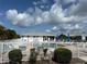 Community pool surrounded by a white fence and lush landscaping under a bright sky at 3300 Loveland Blvd # 602, Punta Gorda, FL 33980