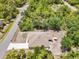 Aerial view of home featuring a patio with dining, screened lanai and proximity to a quiet, lush neighborhood at 3322 Hampton St, Port Charlotte, FL 33948