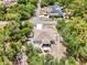 Aerial view displays a home's outdoor living space, including a screened lanai, patio dining and its lush, green surroundings at 3322 Hampton St, Port Charlotte, FL 33948