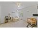 Cozy bedroom features neutral walls and carpet, a ceiling fan, and a comfortable seating area with couch at 3322 Hampton St, Port Charlotte, FL 33948