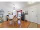 Dining room boasts hardwood floors, a stylish chandelier, and a view of the front door at 3322 Hampton St, Port Charlotte, FL 33948
