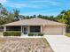 Charming single-story home with a well-manicured lawn, a two-car garage and an American flag in the front yard at 3322 Hampton St, Port Charlotte, FL 33948