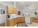 Bright kitchen featuring wood cabinetry, white countertops, and appliances with views to the adjacent living area at 3322 Hampton St, Port Charlotte, FL 33948
