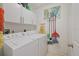 Laundry room with storage cabinets, washer, dryer and cleaning supplies for convenience at 3322 Hampton St, Port Charlotte, FL 33948