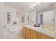 Well-lit main bathroom boasts double sinks, vanity and a tub with decorative fixtures and ample counter space at 3322 Hampton St, Port Charlotte, FL 33948