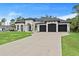Stunning home with a three-car garage, lush lawn, and circular driveway at 3393 S Haberland Blvd, North Port, FL 34288