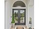 Elegant front door with a transom window, complemented by decorative plants and a 'Welcome' mat at 3393 S Haberland Blvd, North Port, FL 34288