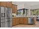 Well-lit kitchen with wood cabinetry, stainless steel appliances, and a scenic view from the large window at 3393 S Haberland Blvd, North Port, FL 34288