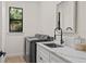 Well-lit laundry room with modern washer, dryer, quartz counters, and stylish fixtures at 3393 S Haberland Blvd, North Port, FL 34288