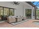 Covered outdoor patio with neutral colored furniture set overlooking the pool and outdoor foliage at 3393 S Haberland Blvd, North Port, FL 34288