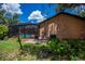 Exterior backyard view with a screened-in pool and lush greenery at 3960 Magara Ter, North Port, FL 34287
