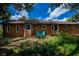 Backyard featuring a well-maintained lawn, lush greenery, and two Adirondack chairs at 3960 Magara Ter, North Port, FL 34287