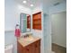 Bathroom featuring a vanity with a granite countertop, mirror, and built-in wooden shelving at 3960 Magara Ter, North Port, FL 34287