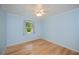 Bedroom with light blue walls, wood floors, ceiling fan, and a bright window view at 3960 Magara Ter, North Port, FL 34287