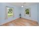 Bright bedroom with hardwood floors, two windows, ceiling fan, and light blue walls at 3960 Magara Ter, North Port, FL 34287