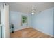 Bedroom with light blue walls, hardwood floors, and a ceiling fan with a light at 3960 Magara Ter, North Port, FL 34287