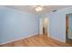Spacious blue bedroom with a walk-in closet, light wood floors, and a ceiling fan at 3960 Magara Ter, North Port, FL 34287