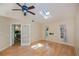 Bedroom with hardwood floors, skylight, ceiling fan, and french doors leading to the kitchen at 3960 Magara Ter, North Port, FL 34287