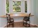 Bright breakfast nook with a built-in bench, bar stools, and a lovely view of the surrounding greenery at 3960 Magara Ter, North Port, FL 34287