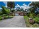 Charming home showcasing a well-maintained lawn, mature trees, and classic exterior features at 3960 Magara Ter, North Port, FL 34287