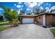 Spacious two-car garage with a concrete driveway, beautiful landscaping, and great curb appeal at 3960 Magara Ter, North Port, FL 34287