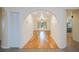 Open archway leading to a spacious room with hardwood floors and a charming window view at 3960 Magara Ter, North Port, FL 34287