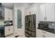 This kitchen features stainless steel appliances, a pantry door, and sleek white cabinetry with black hardware at 4294 Wooley Ave, North Port, FL 34287